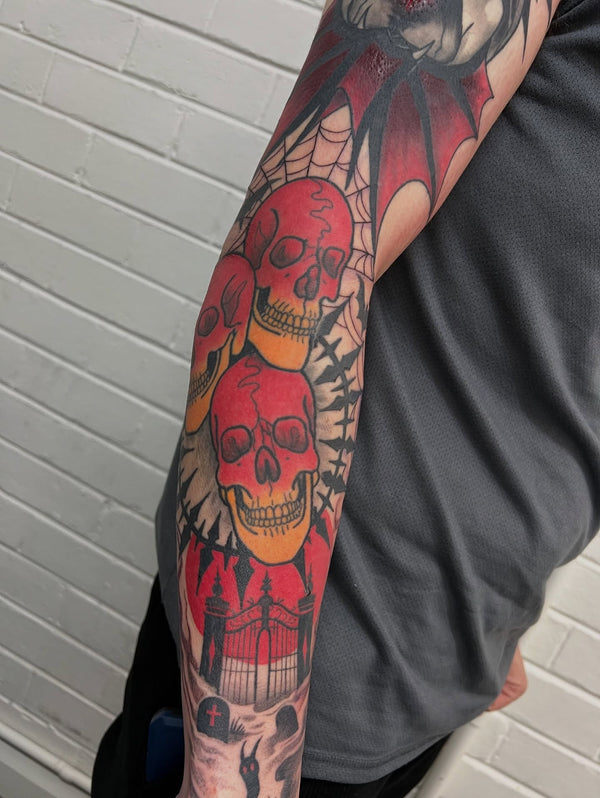 Traditional red skulls tattoo on forearm