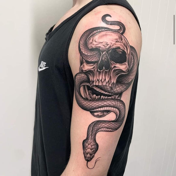 Black and grey skull and snake tattoo on upper arm